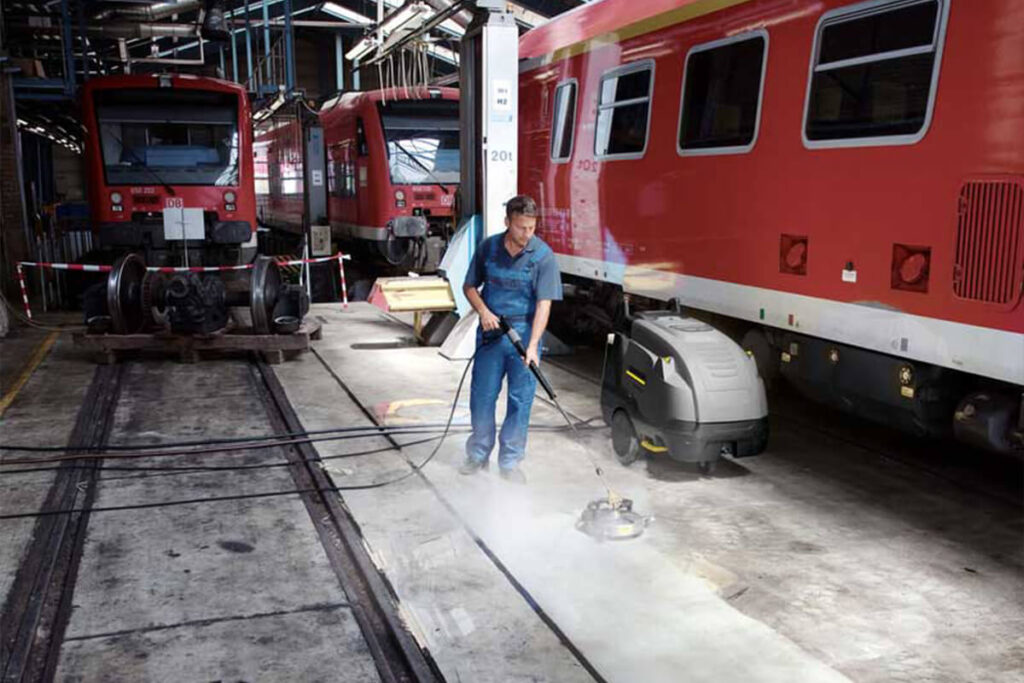 Man using HDS-E-FR-30 pressure washer in engine shed