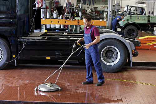 Man cleaning a car workshop floor