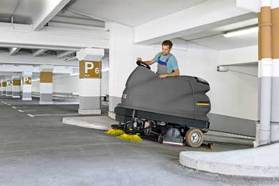 Scrubber dryer cleaning a car park