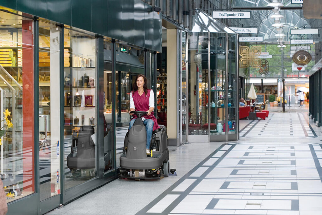 Woman riding B 90 floor scrubber in shopping centre