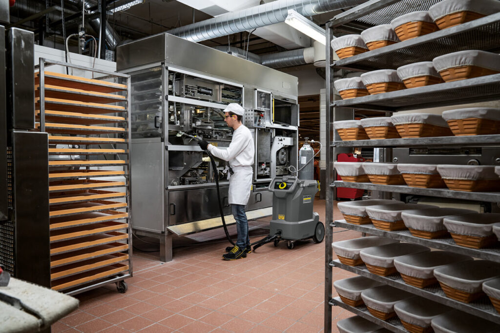 Man wearing kitchen whites using IB 10/8 dry ice blaster in industrial kitchen