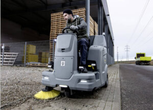 KM 100/120 battery ride on floor sweeper sweeping a path